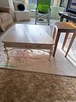 Full view of coffee table, end table, and area rug in a living room setting.