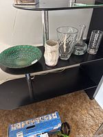 Shelf with one decorative bowl and four vases of varying sizes and materials shown.