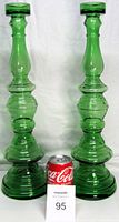 Pair of tall green glass tealight candle holders with Coca-Cola can for size reference. Both show the detailed stepped base and tapered shape.