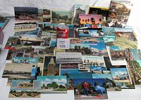 Wide view of all 58 American postcards spread out showing a variety of scenes and colors, including a soda can for scale.