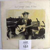 Cover of Neil Young Comes A Time vinyl album showing black and white photo of Neil Young with guitar, mellow studio background, edges worn and soiled.