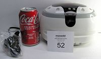 Nexxtech ultrasonic cleaner shown next to a Coca-Cola can for size reference, includes power cord and plastic basket.