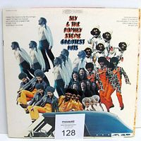 Front of Sly And The Family Stone Greatest Hits album jacket showing colorful group collage photo of band members with car roof photo at bottom and song list on side.