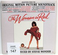 Front cover of The Woman In Red soundtrack vinyl LP record showing title, images, and artist credits.