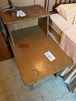 Mid-Century Modern bedside telephone table showing surface wear and finish discoloration.
