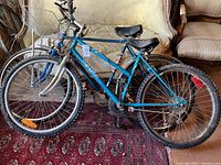 Three bicycles stacked indoors on rug showing condition and frame details.