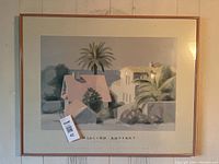 Framed print by William Buffett showing houses and palm trees in muted colors.