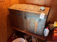 Closed view of the large antique wooden chest with metal bands and patina