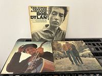 Front covers of three Bob Dylan vinyl LP records, showing The Times They Are A-Changin' and two other albums with vintage photography on covers.