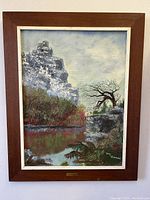 Front view of framed oil painting depicting a cliffside landscape with river, tree, and rocky outcrop, signed by Tony Hammond.