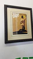 Framed art print hanging on wall showing full piece and frame