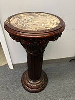 Full view of wooden pedestal stand with marble top