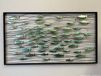 Front view of entire metal school of fish wall hanging