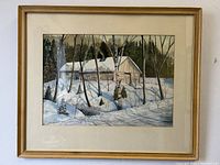 Framed watercolour painting showing a cabin with snow and trees.