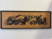 Full view of the framed lithograph showing the horizontal stretched format and stylized black animal figures on tan background