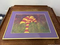 Frontal view of framed abstract chalk pastel painting titled 'Whimsey #2', shows artwork matted with purple border and gold frame.
