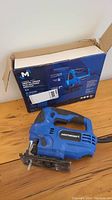 Blue Mastercraft orbital jigsaw with attached saw blade, showing general condition and original box in background.