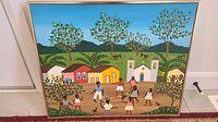 Full view of colorful folk art painting showing village scene with dancing people, fruit trees, houses, and church.