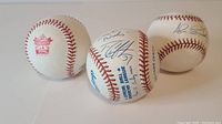 Three official MLB American League baseballs, one unsigned from Toronto Blue Jays Coca Cola All-Star Fanfest, two signed by Tim Crabtree and Alex S. Gonzalez.