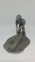 Front angled view of the collectible pewter lumberjack figurine showing the figure chopping a log with an axe.