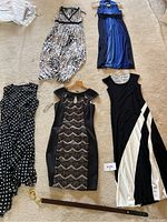 Five dresses laid out on floor showing styles and patterns