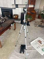 Full view of Bausch & Lomb telescope mounted on Hakuba EV tripod, Bushnell binoculars at tripod base, indoor setting