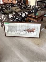 Straight-on front view of full framed print leaning against floral couch