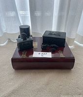 Overview of entire lot including two carved boxes, cylindrical container, and small animal carvings on a wooden surface.