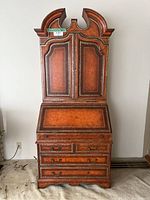 Full front view of desk showing overall form: upper cabinet, drop-front panel, lower drawers