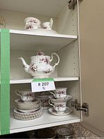 Shelf view showing two rectangular serving trays and sugar and creamer atop cabinet