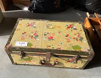 Top view of the vintage Disney child's trunk showing illustrations of Disney characters and metal reinforcement corners.