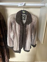 Full view showing fur coat hanging in closet on a hanger with a visible Hudson's Bay label.