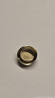 Close-up photo of a single round cabochon cut lemon citrine gemstone showing color, shape and transparency.