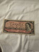 Front of a 1954 Canadian two dollar bill showing portrait of Queen Elizabeth II with serial number 35589306.