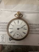 Round Waltham pocket watch with white dial, Roman numerals, 24-hour inner circle and sub-second dial.