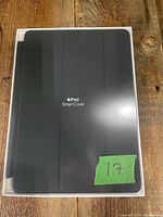 Front of Apple iPad Smart Cover in black inside clear plastic packaging with Apple iPad Smart Cover text visible