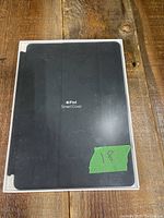 Front view of sealed black Apple iPad Smart Cover box with product name visible.