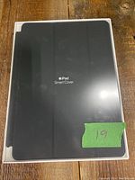Front view of Apple iPad Smart Cover packaging in black color, showing product name and sealed box.