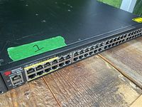 Front angle view showing multiple Ethernet ports with yellow bordered PoE ports on left side and Brocade logo.