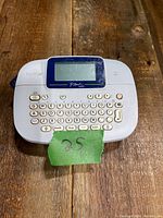 Front view showing the label maker keyboard, screen, and brand markings.