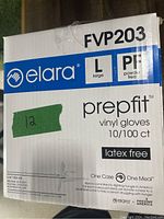 Photo of a cardboard box showing branding 'elara', product name 'prepfit vinyl gloves', size large, powder free, latex free, quantity 10 boxes of 100 gloves each