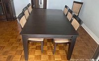 Full view of the dark wood rectangular dining table with chairs around it. The table seats 8 when fully extended.