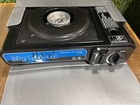 Top view of the MyLand portable gas stove showing burner and control knob.
