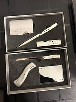 Set of four metallic Beverly Hills Polo Club letter openers in black foam trays inside a box