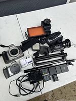 Overview of cameras, lenses, lighting, and accessories on table