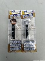 Two new Harry Potter PEZ dispensers in original packaging with refills, one depicting Harry Potter, the other a Dementor.