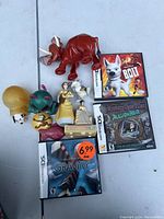 Nintendo DS games (Bolt, Mystery Case Files: MillionHeir, Gravity) and various dog-themed figurines and toys in plastic and plush.