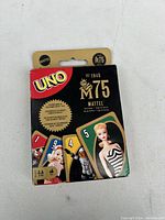 Photo of the Uno 75th Anniversary sealed card game box showing vintage-themed card art and anniversary logo.