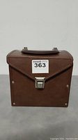 Closed brown vinyl record carrying case with metal clasp and handle