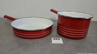 Red frying pan and saucepan set showing overall condition and design